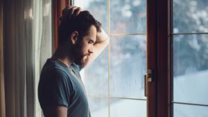 Business owner struggling with depression, staring out of a window